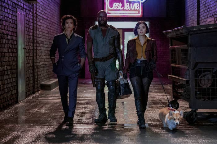 JOHN CHO as SPIKE SPIEGEL, MUSTAFA SHAKIR as JET BLACK, DANIELLA PINEDA as FAYE VALENTINE, and Ein the corgi walking down an alley