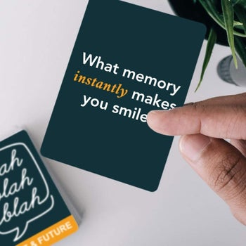 hand holding a card that asks, what memory instantly makes you smile