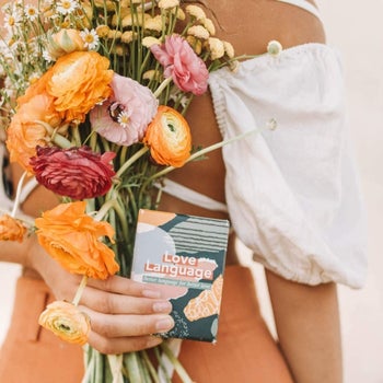 person holding the box of cards with a bouquet 
