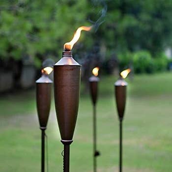 Four lit tiki torches