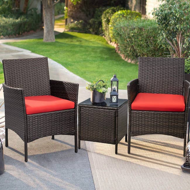 Two patio chairs and a matching table placed in a backyard setting