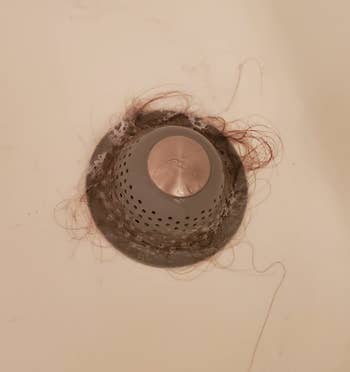 a reviewer's drain protector catching hair in the tub 