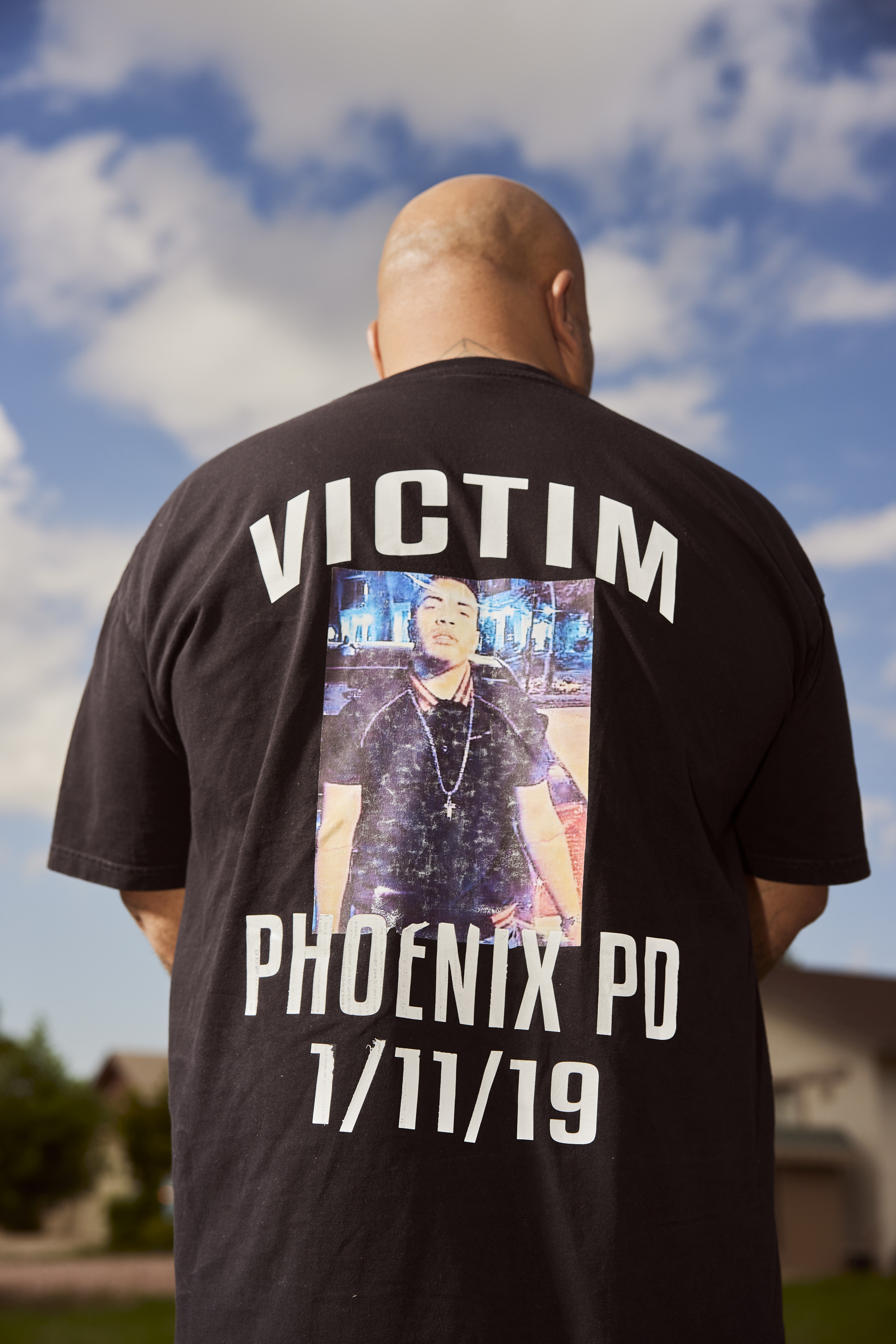 Roland photographed from the back, his T-shirt reads Victim Phoenix PD 1/11/19, with a photograph of Jacob