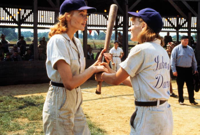 Geena Davis and Lori Petty fighting over a baseball bat.