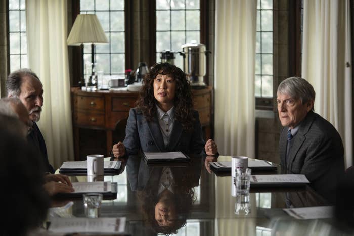 Sandra Oh sitting a desk during a meeting in a scene from The Chair
