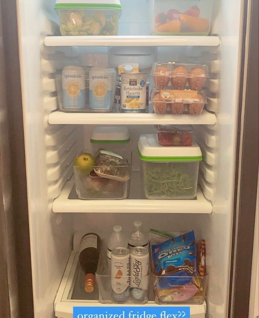 Inside of a fridge with various clear containers full of vegetables and fruit