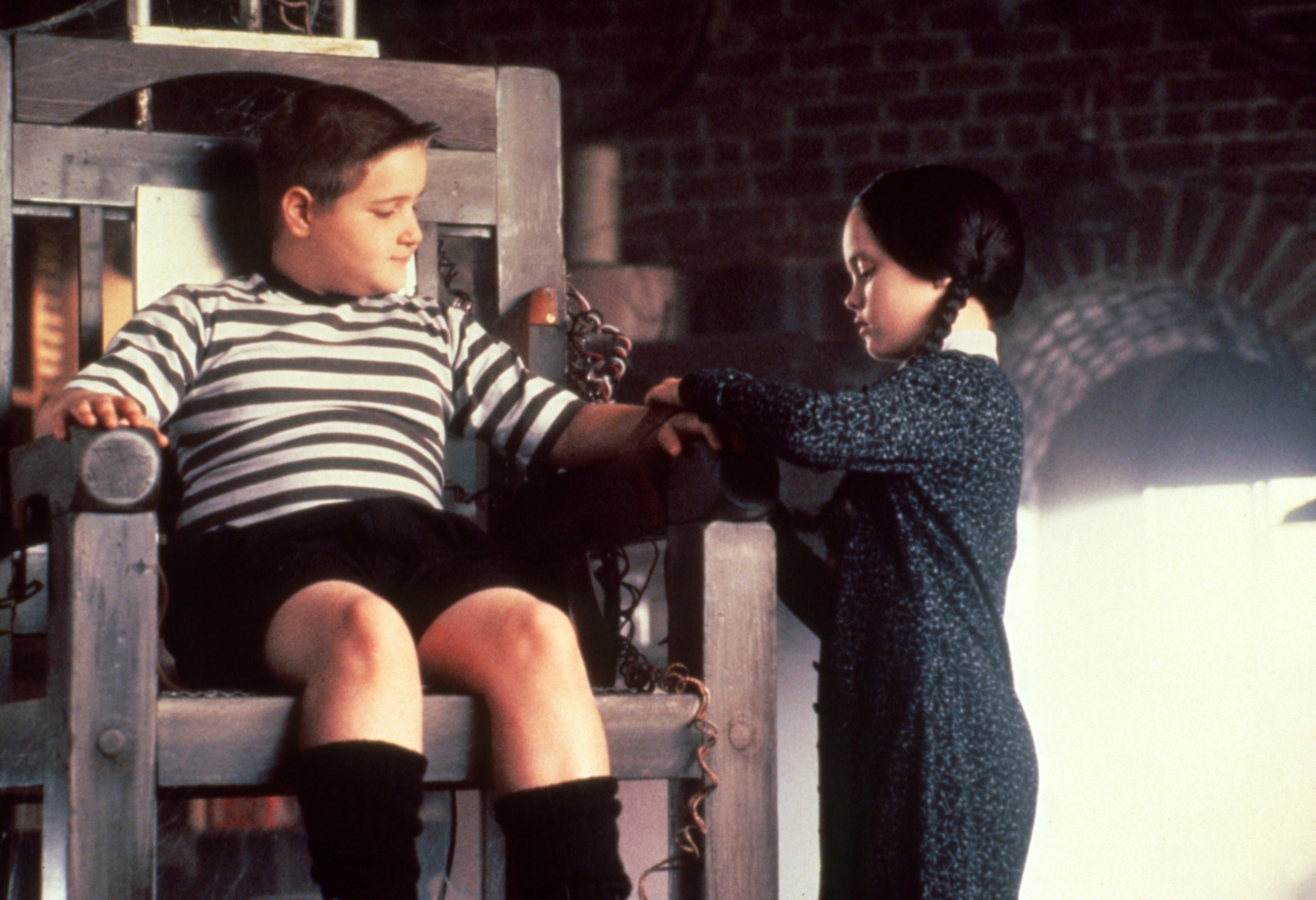 Jimmy Workman sitting in a chair while Christina Ricci ties his arm.