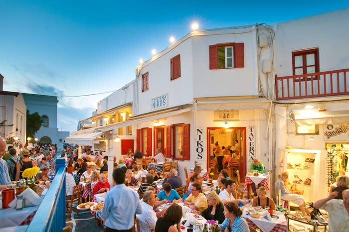 A busy restaurant outdoors in Greece.