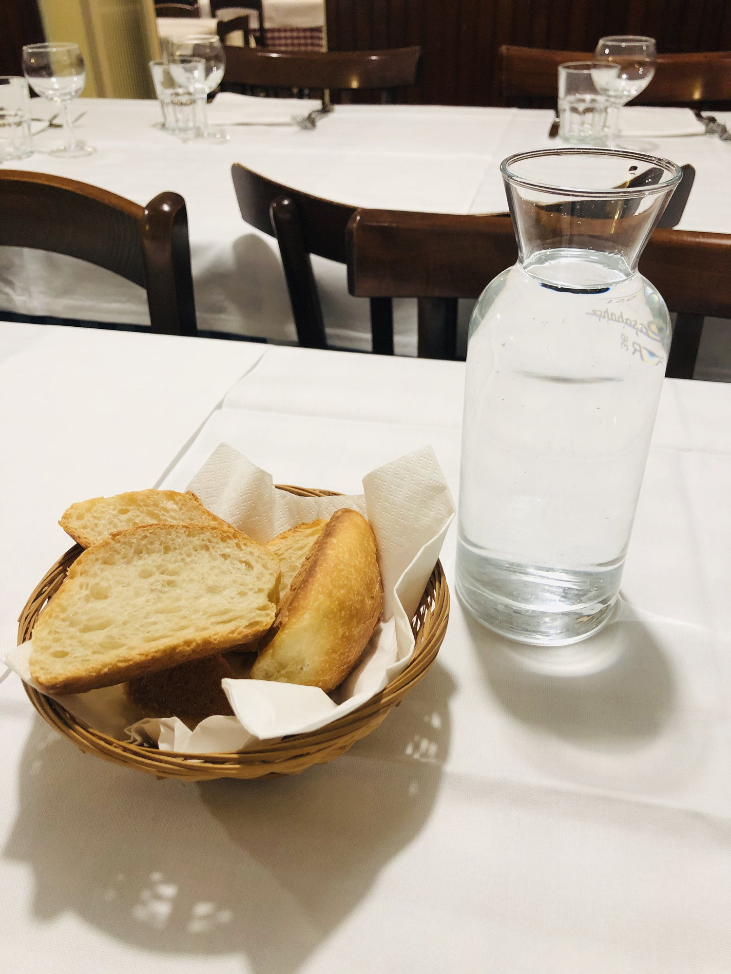 A bread basket on a table at a restaurant.