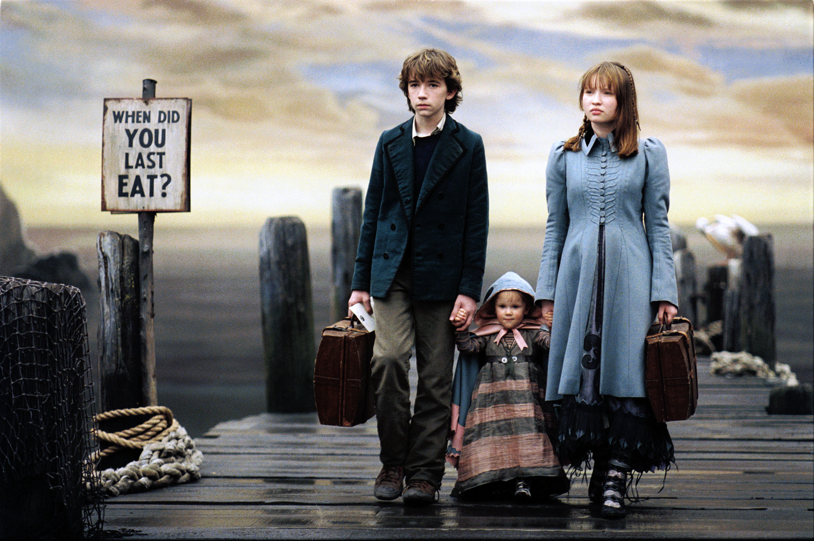Liam Aiken, Kara/Shelby Hoffman, and Emily Browning holding hands while walking on a dock.
