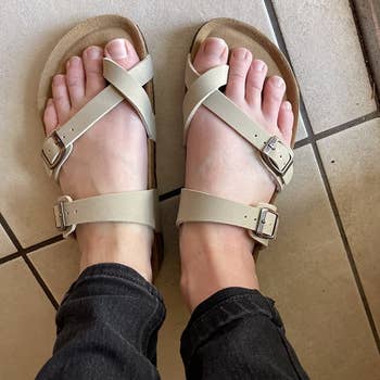 a pair of reviewer's feet wearing the sandals 