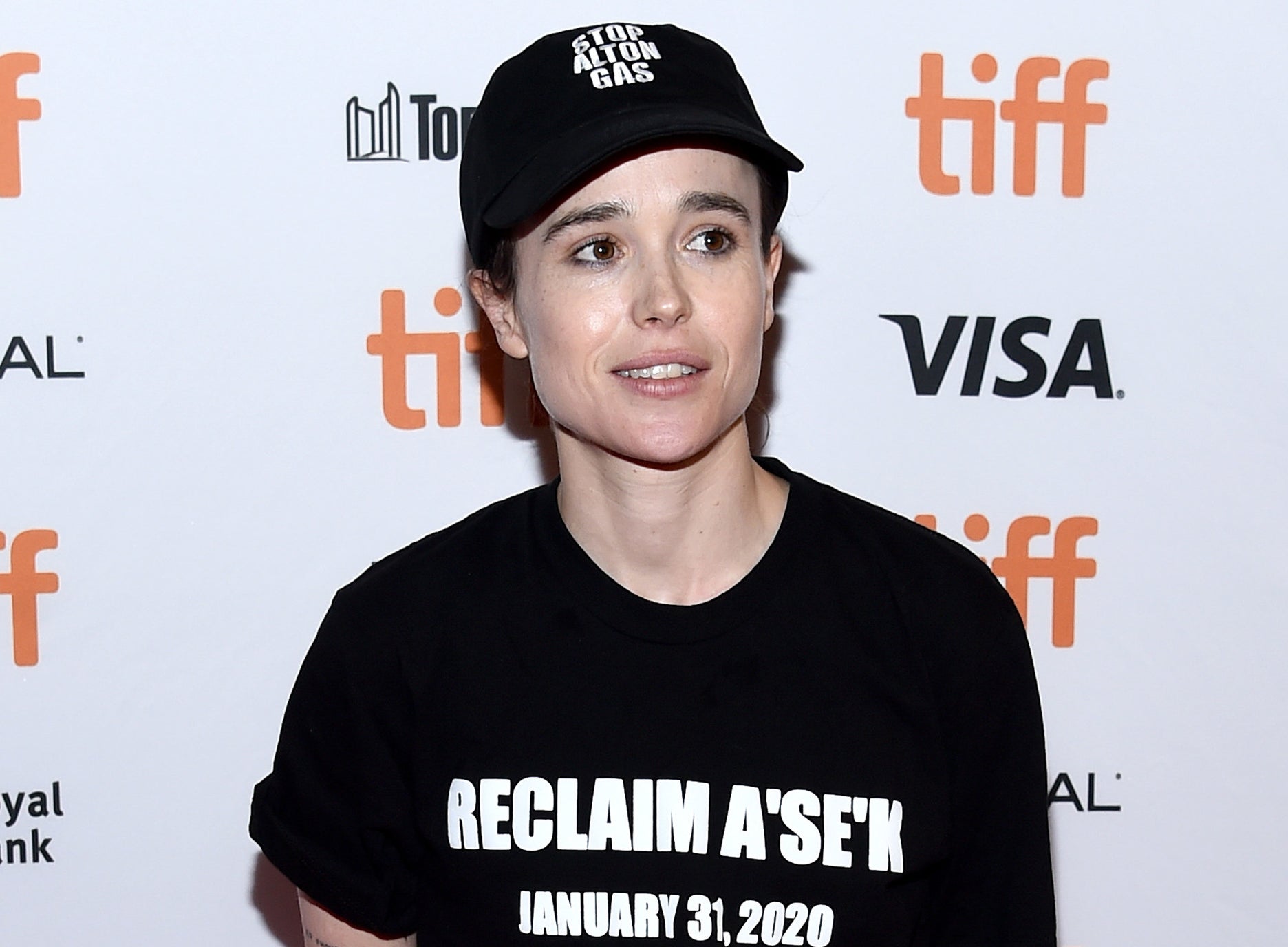 Elliot wears a baseball cap and black t-shirt while attending an event