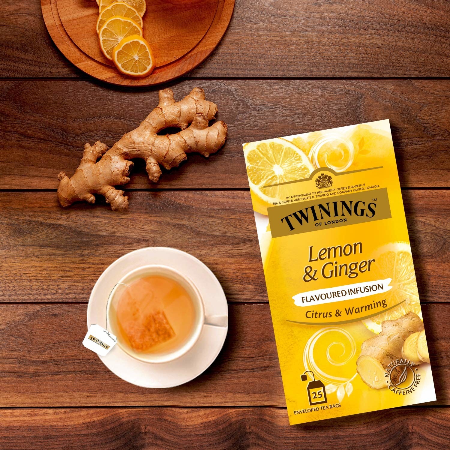 The box of tea placed next to lemon slices, some ginger, and a cup of tea