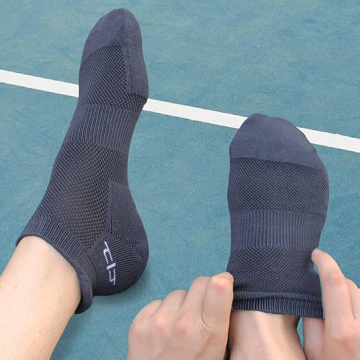 A person pulling up socks on their feet