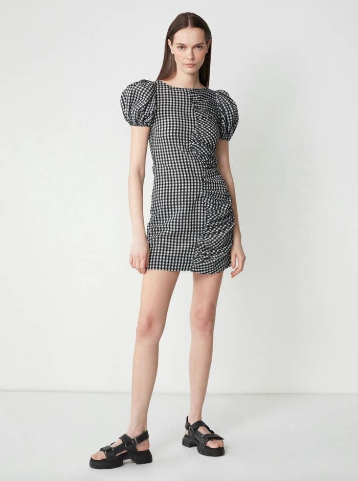 the sheersucker Ganni check dress with puff sleeves on a model in sandals