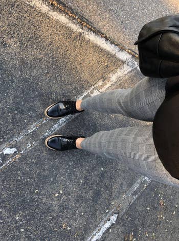 reviewer taking a photo from above and down towards legs showing the plaid gray print
