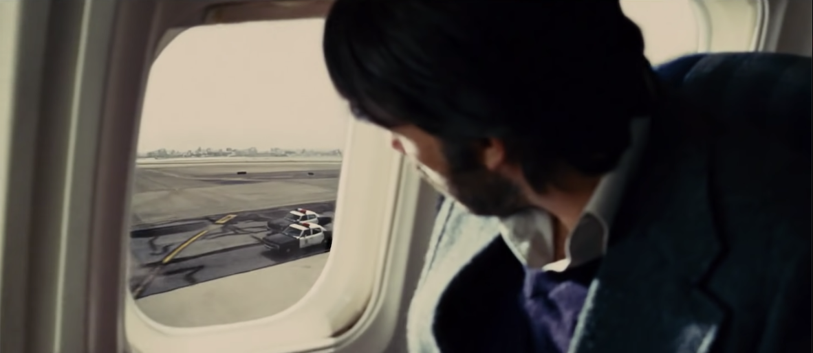 Tony Mendez watches police cars from inside the airplane
