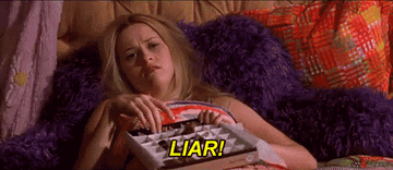 Elle sits in bed with mussed hair, sadly eating chocolates and watching TV, screaming &quot;LIAR!&quot;