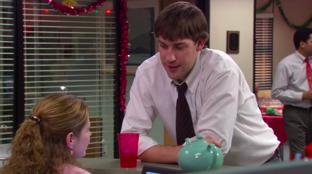 Jim leaning over Pam&#x27;s desk with the turquoise teapot