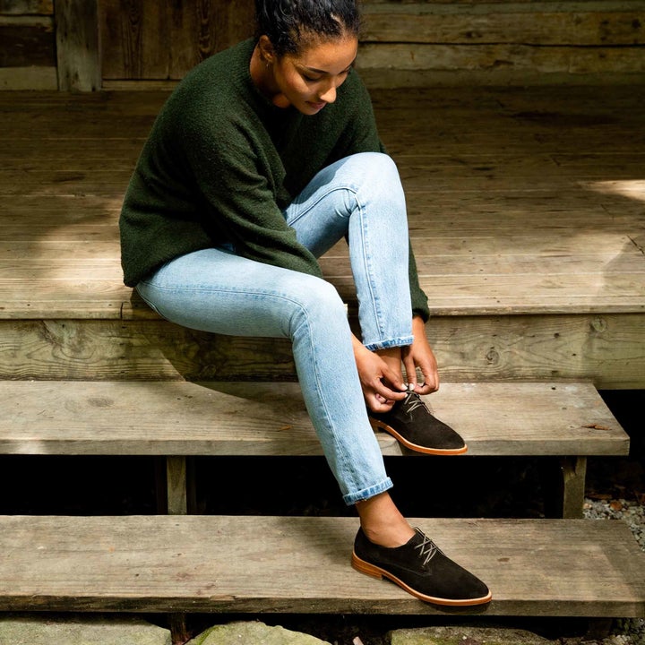 model sitting tying the laces of the oxford loafers