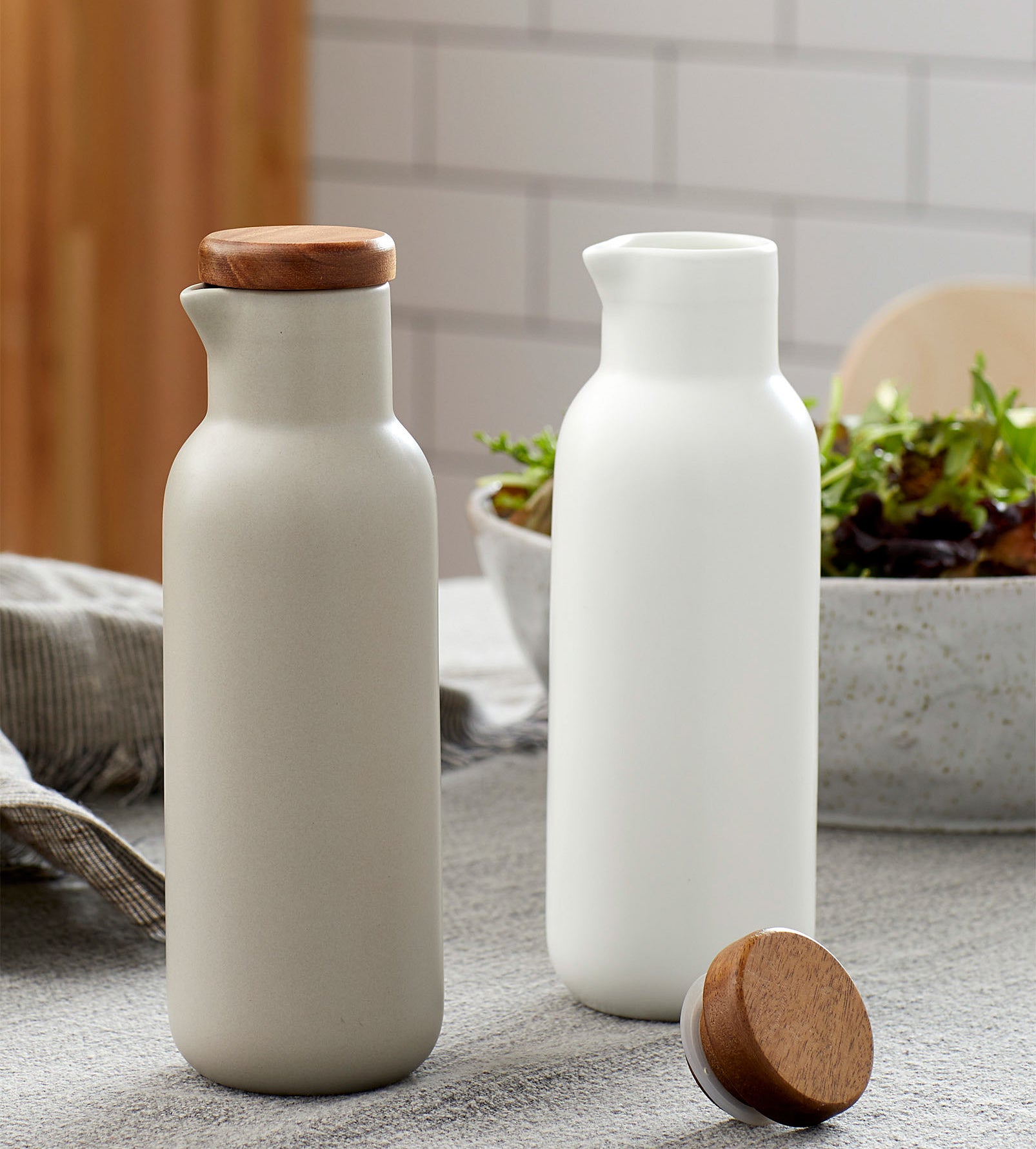 A pair of porcelain oil and vinegar bottles on a kitchen table