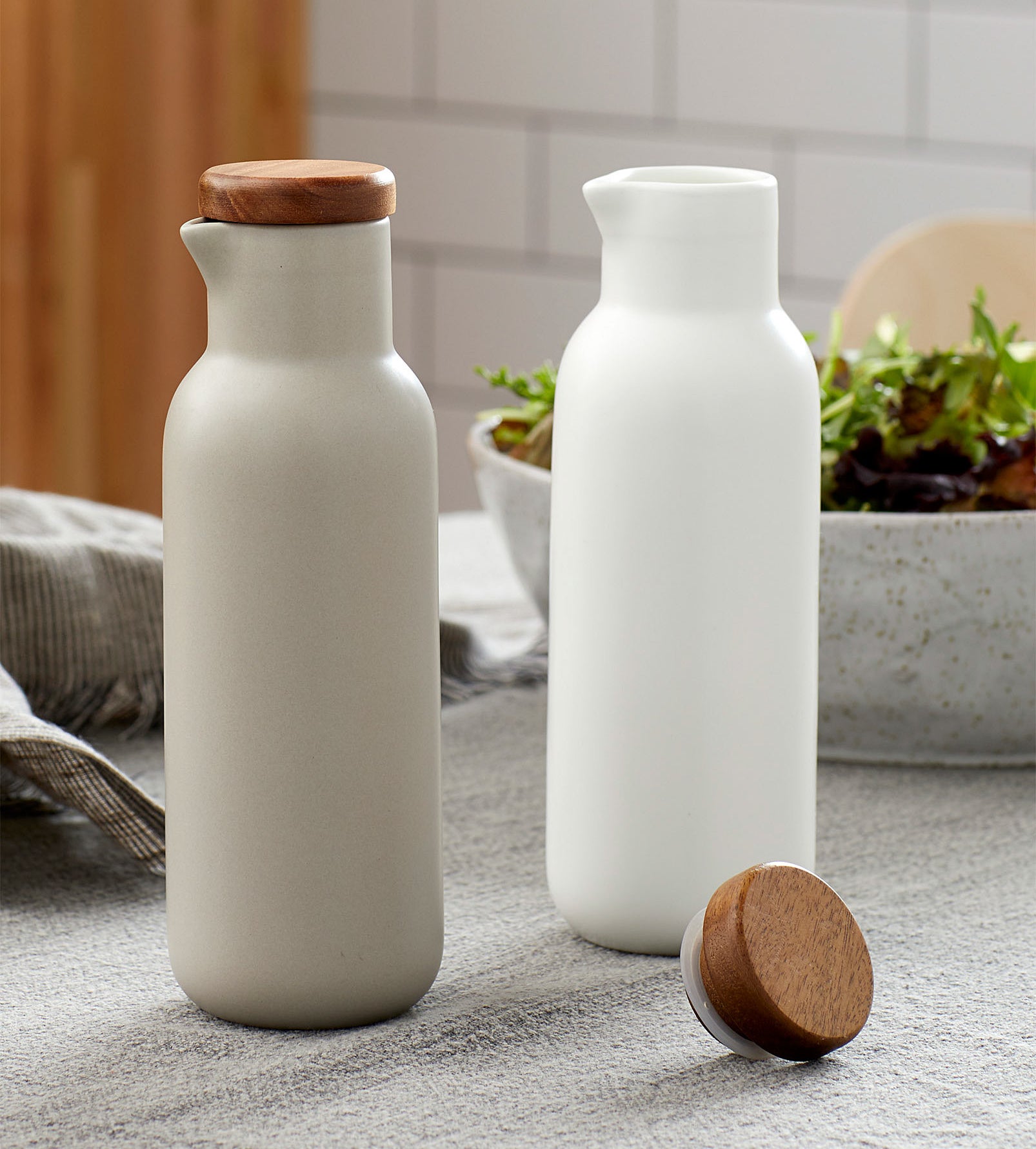 A pair of porcelain oil and vinegar bottles on a kitchen table