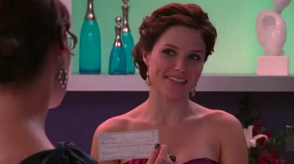 Brooke holding up the check Millie wrote her on "One Tree Hill"