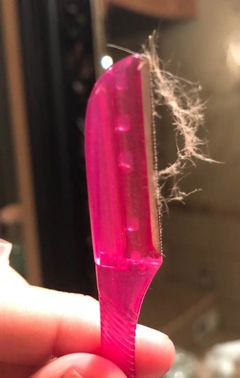 a reviewer photo of the razor with shaved peach fuzz attached 