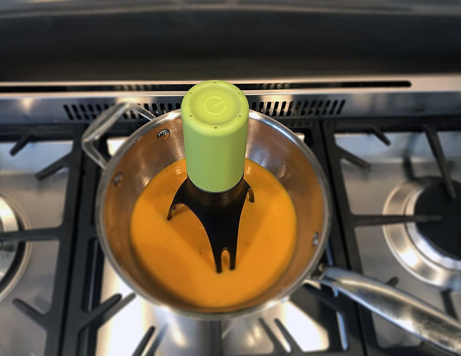 green automatic stirrer in a pot with soup