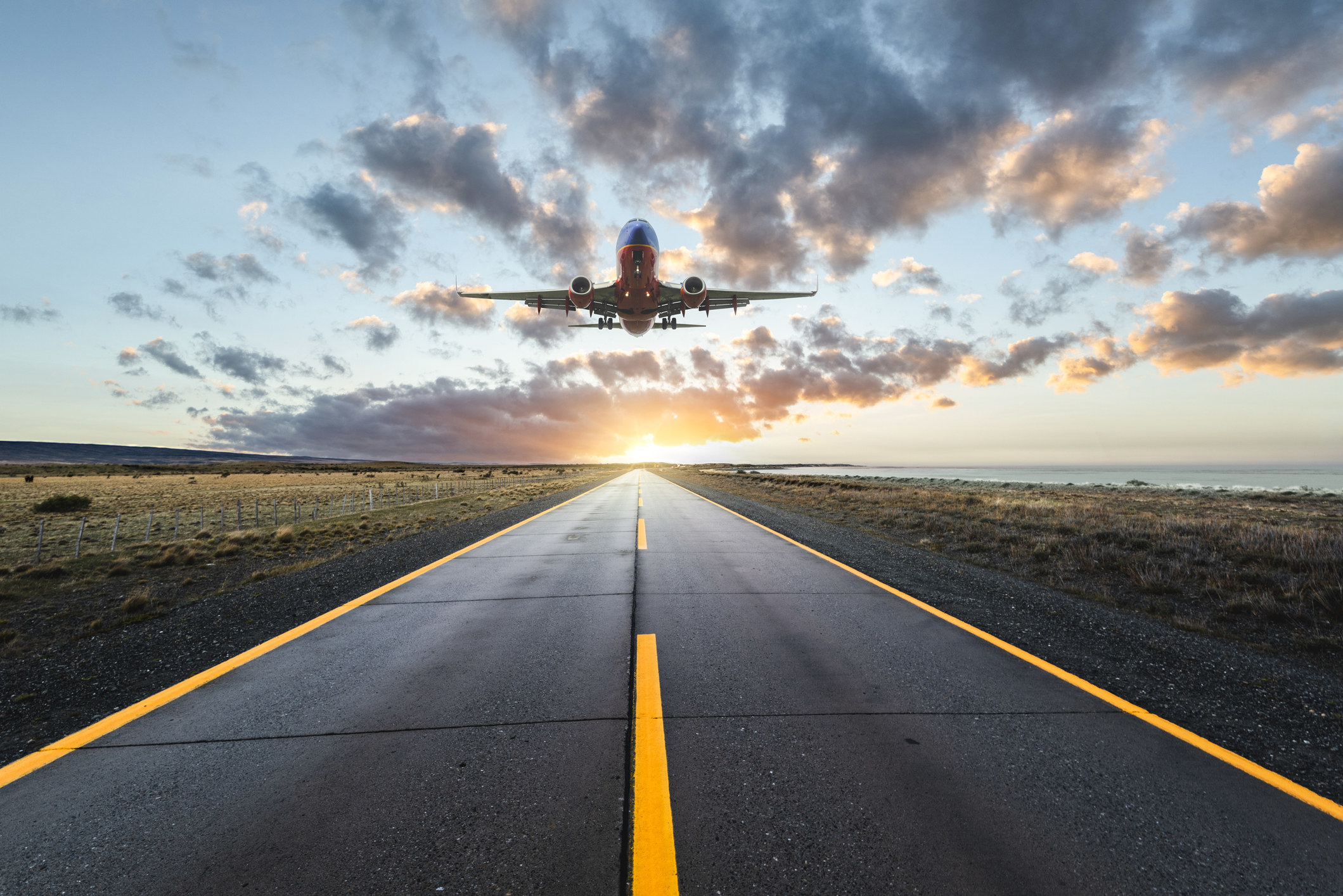 An airplane landing at sunset.