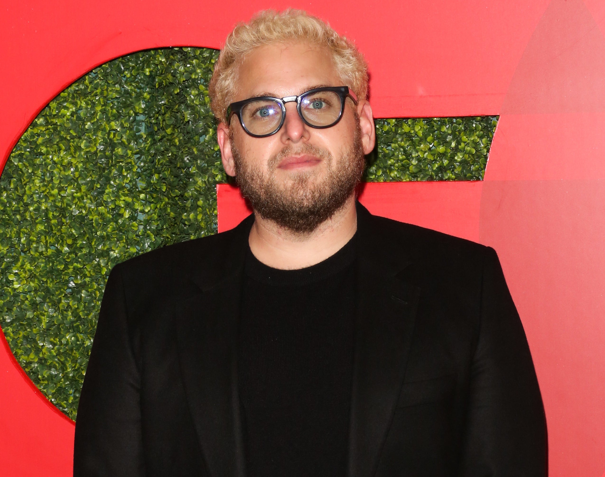 Jonah, with bleached hair, wears a black tee with black blazer