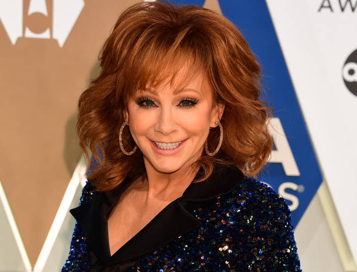 Reba smiles while wearing a black sequined blazer