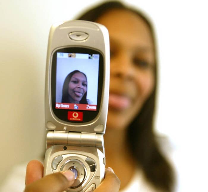 Samantha Mumba taking a selfie with a flip phone
