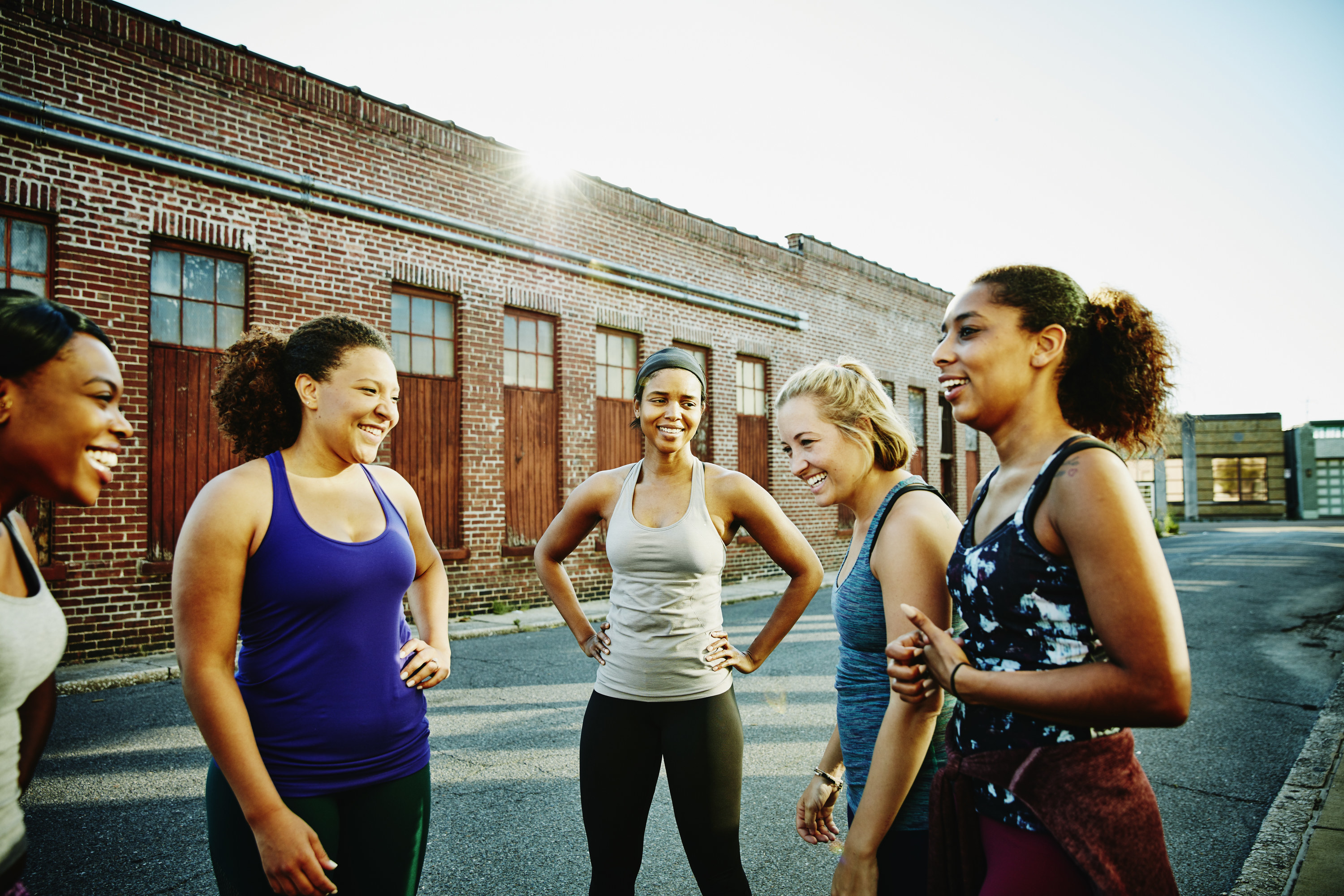 A group of women smile as they get ready to run