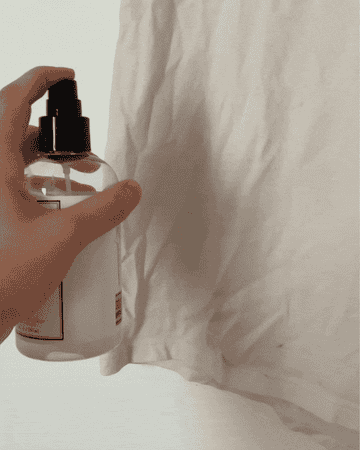 Gif of the writer spraying a white T-shirt with a Crease Release spray