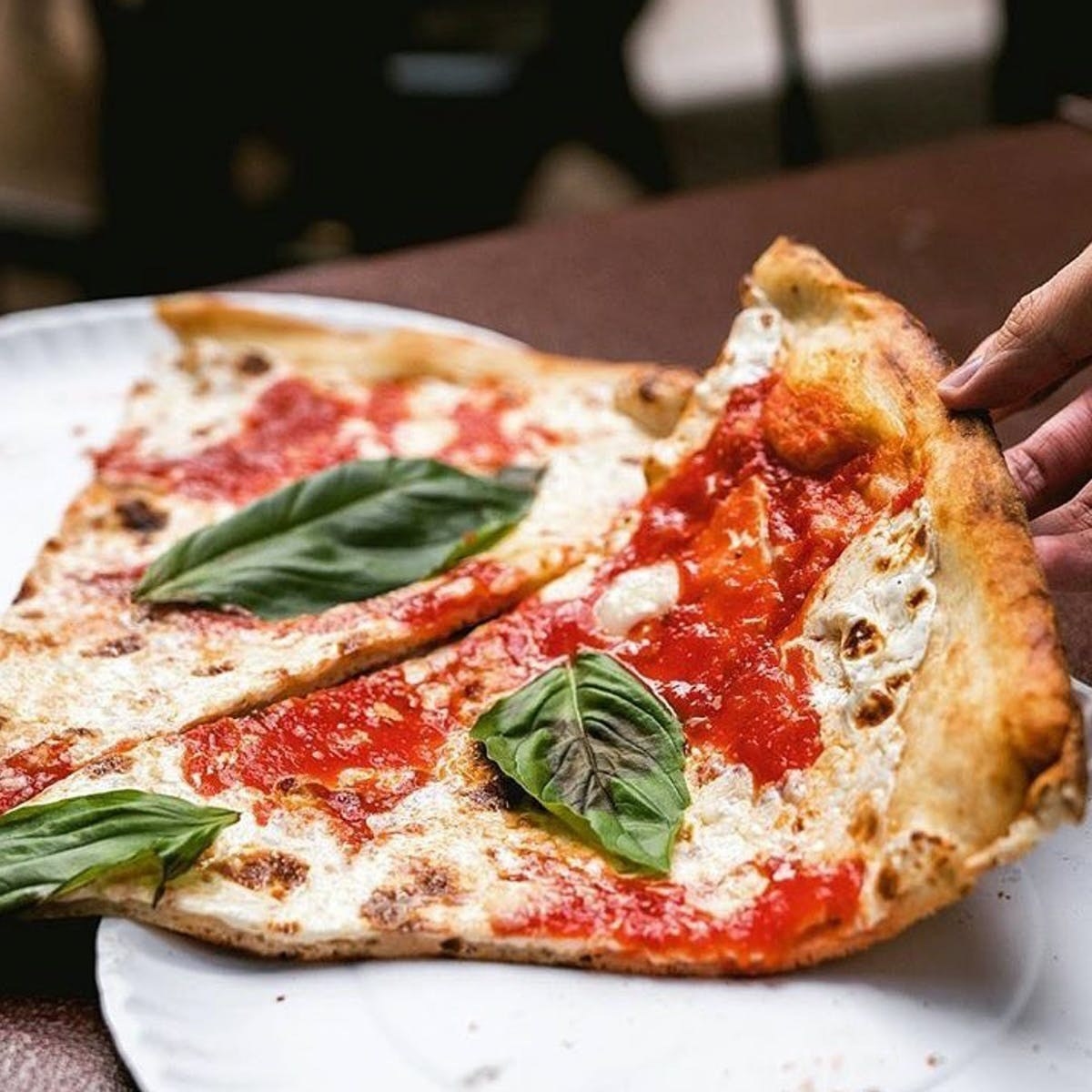 a slice of pizza with tomato sauce, fresh mozzarella, and basil
