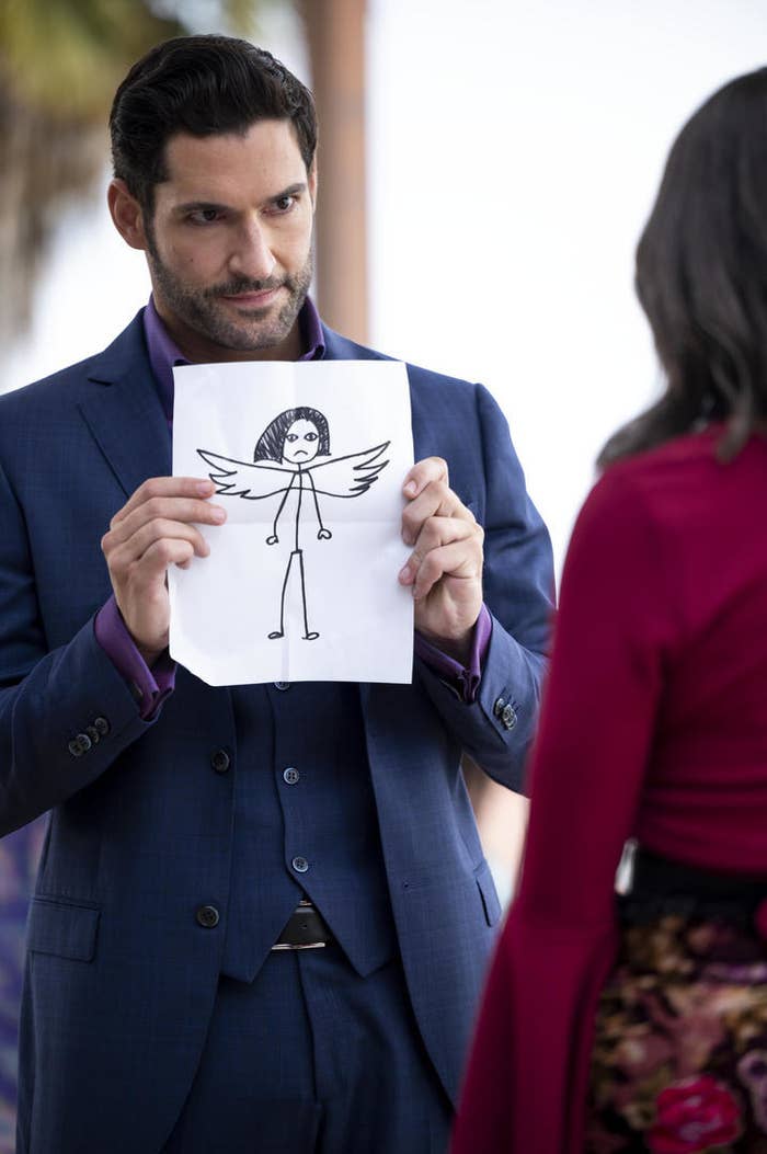 Lucifer holding up a crude pencil drawing of an angel
