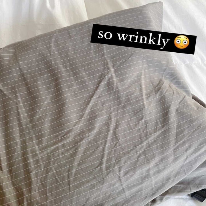 A grey pillow case with wrinkles