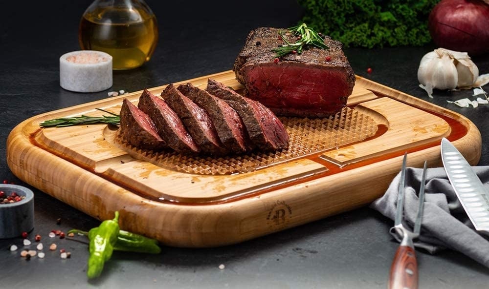 thick cutting board with roast resting on grooved center and juice collected in grooves