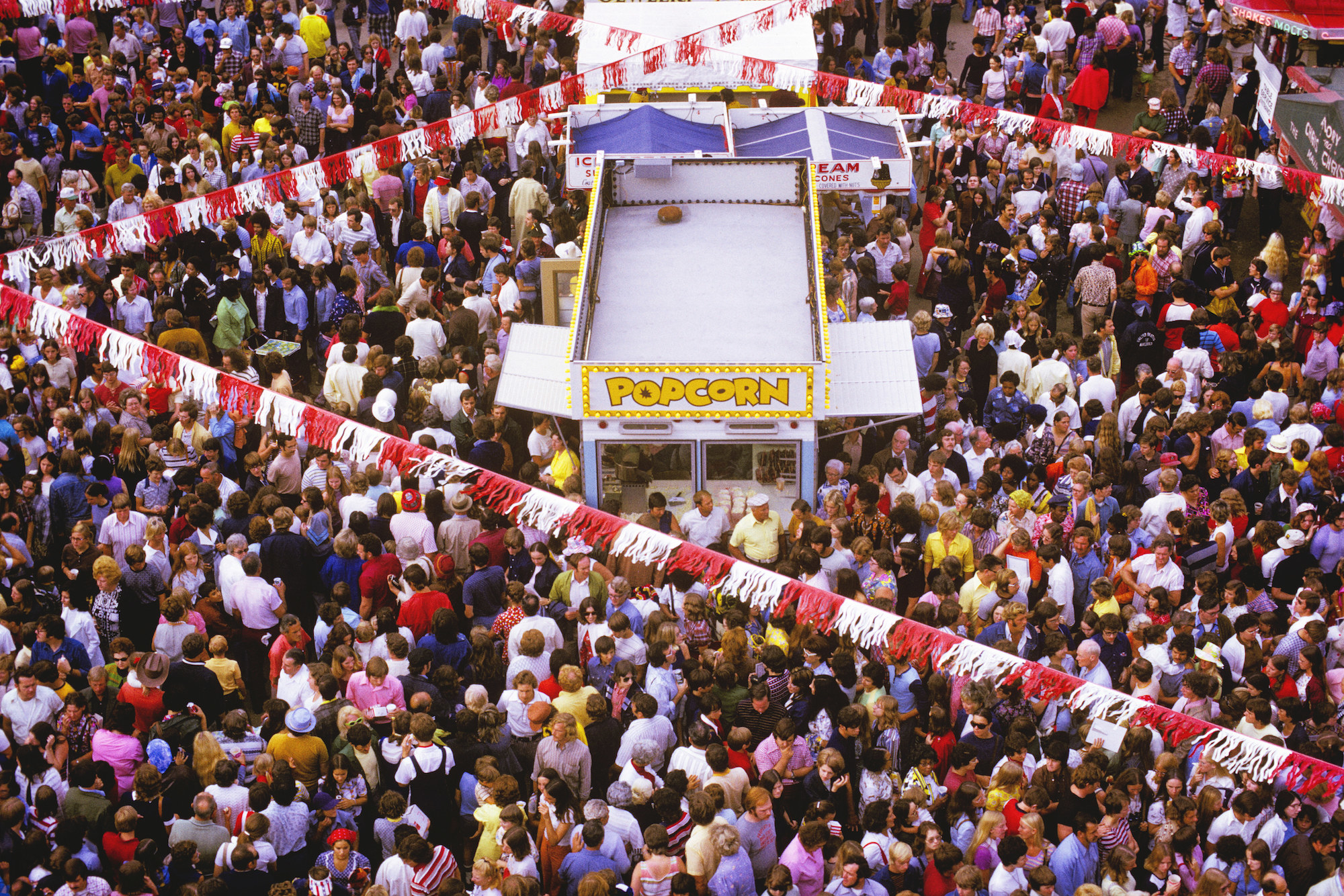 A large crowd of people attends a fair