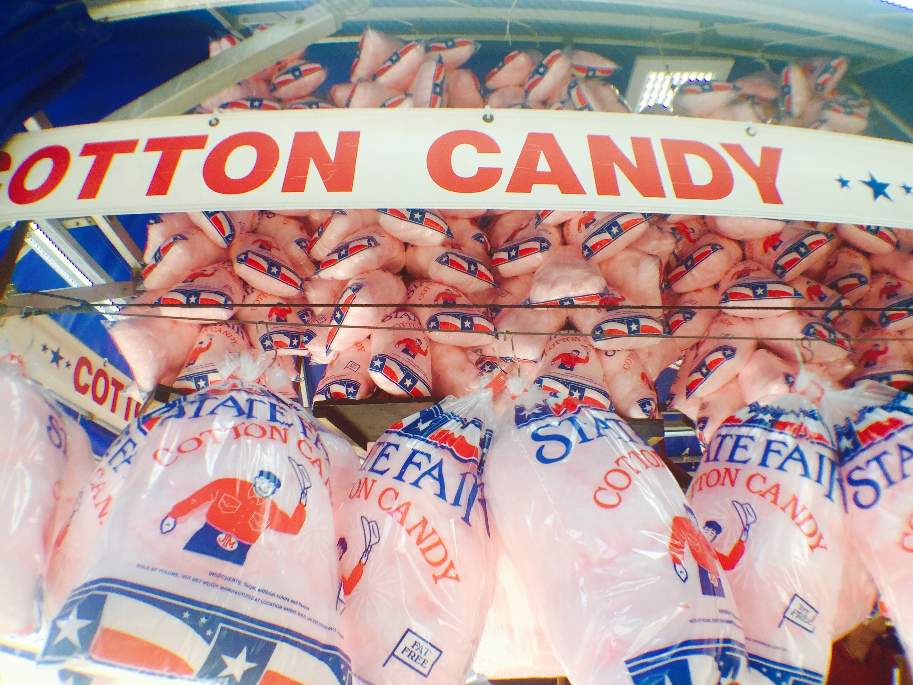 Bags of cotton candy are seen hanging on a vendor cart at the State Fair of Texas
