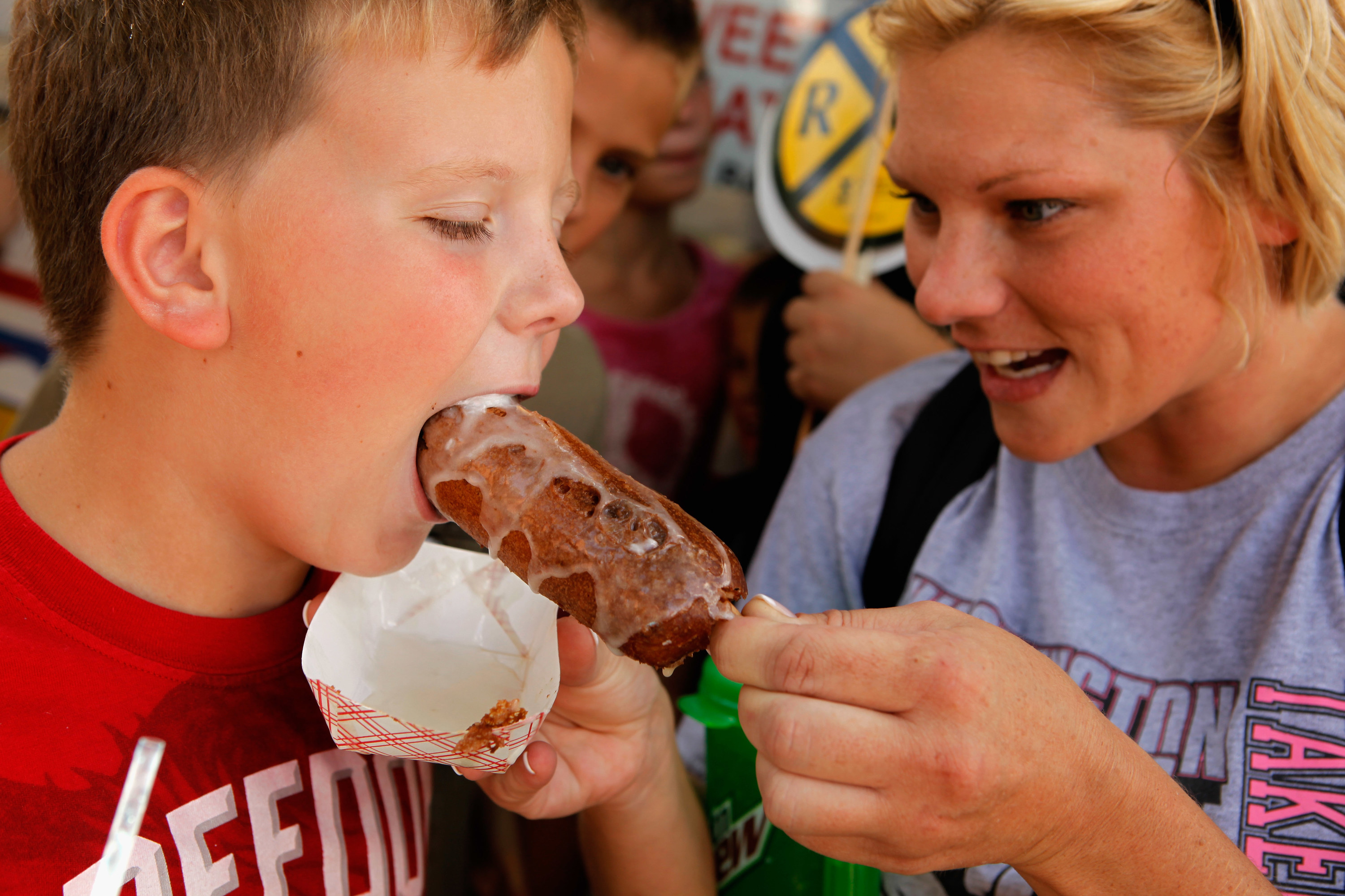 A woman feeds her son a food item at the Iowa State Fair