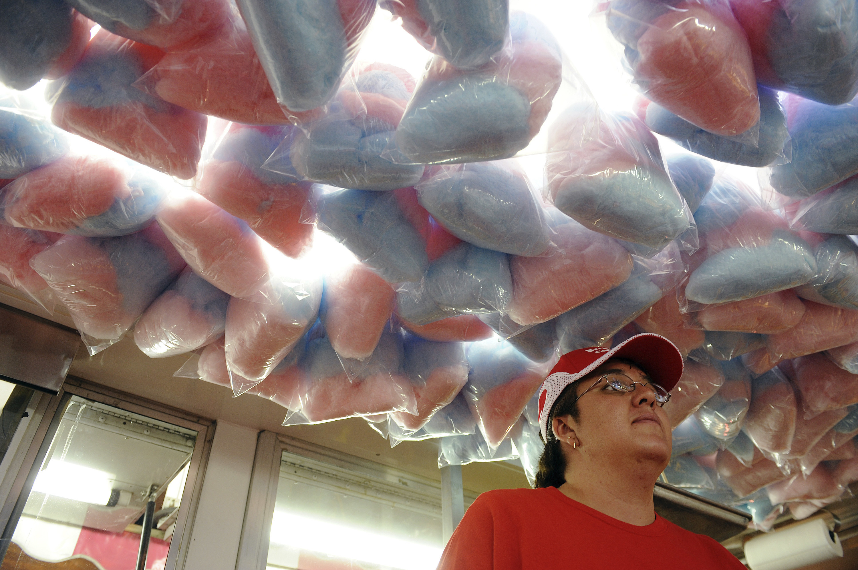 A female worker stands under cotton candy at the Colorado State Fair