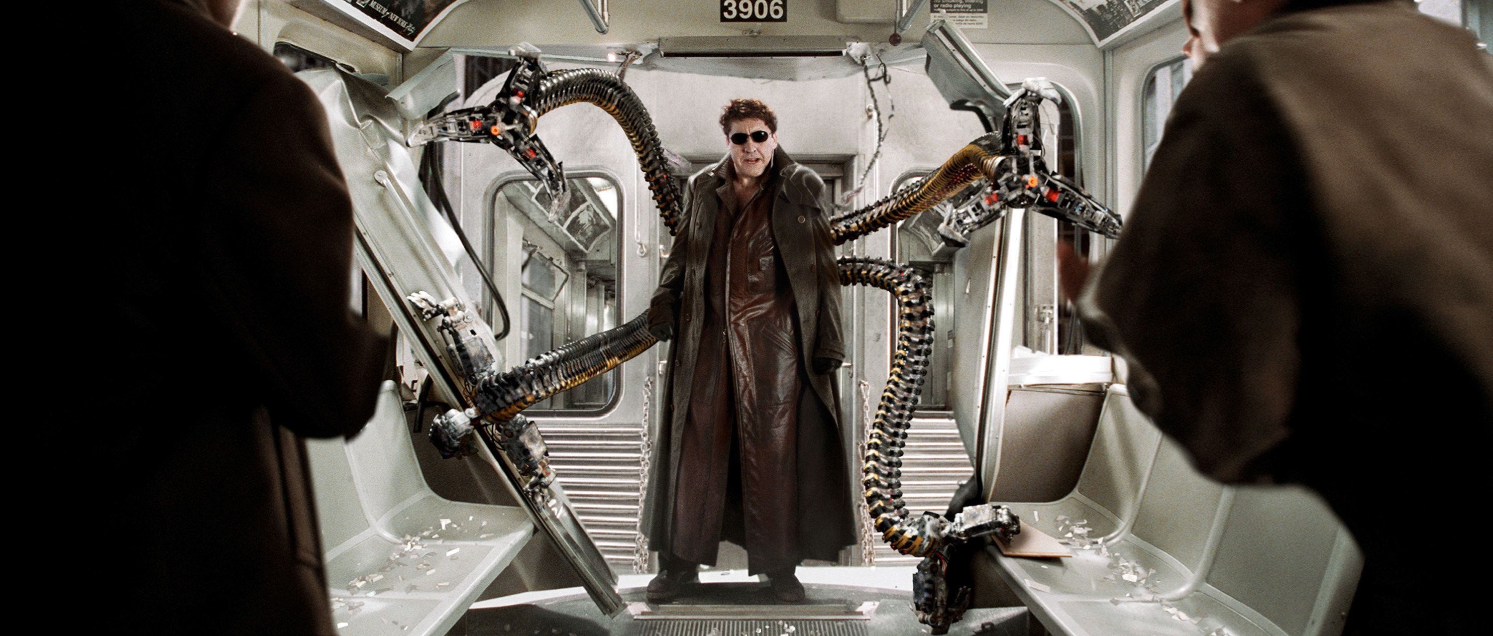 Alfred Molina stands in the back of a train with his tentacles reaching and grasping as Doc Ock in Spider-Man 2