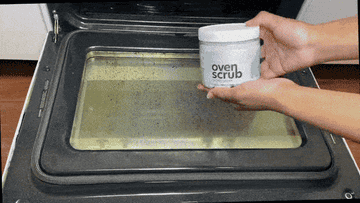 person using oven scrub cleaner to get rid of stains on oven