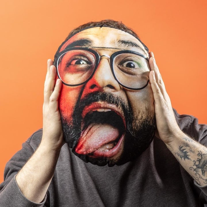 person holding a pillow in front of their face. the pillow looks like their own head.