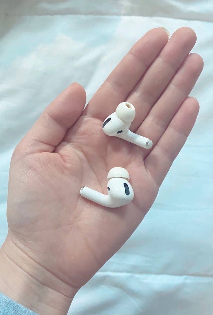 A the airpods in a reviewer&#x27;s hand