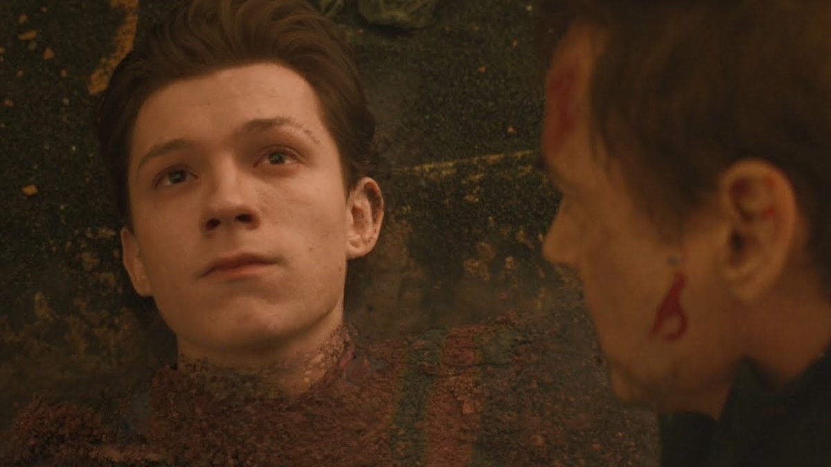 Peter Parker lies on the ground as his body turns to dust while Tony Stark looks down at him in Avengers: Infinity War