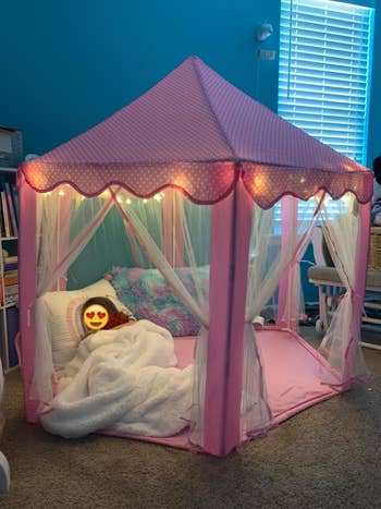 Reviewer's child snuggled up in the pink lit up tent
