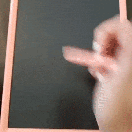 gif of a reviewer's video showing them scribbling on the pink writing tablet with a stylus